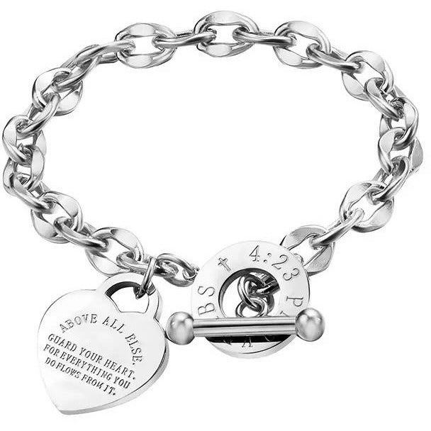Stainless steel inspirational, heart charm bracelet that’s engraved with the motivational saying, “Above all else, guard your heart, for everything you do flows from it. Proverbs 4:23” Silver