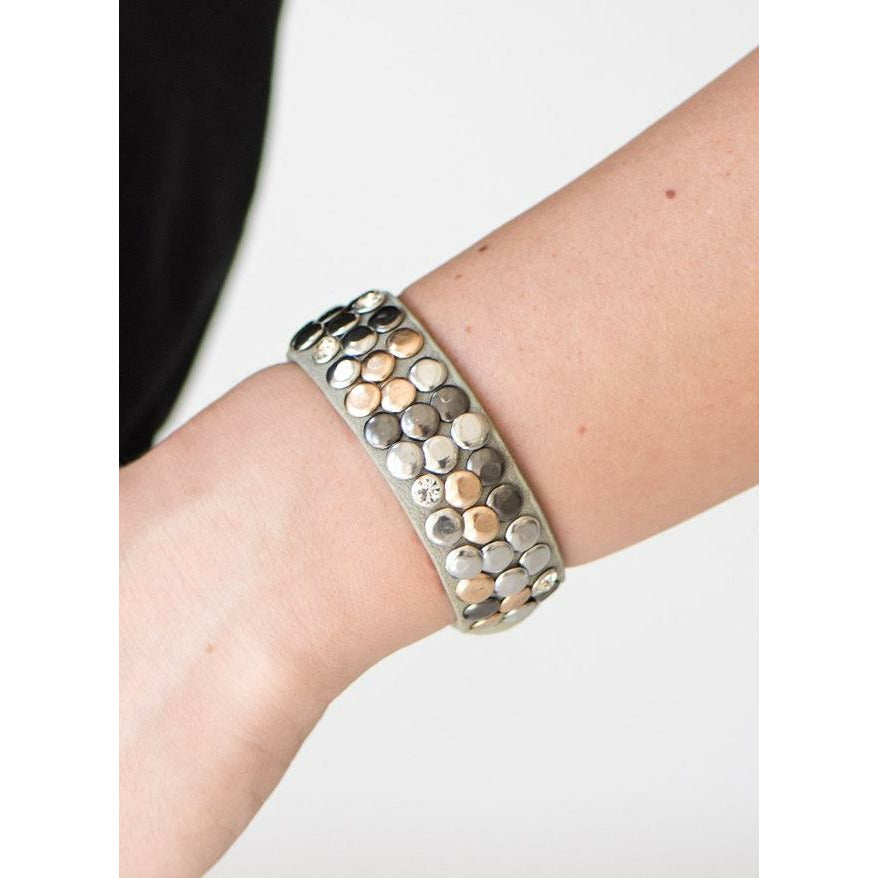 gray leather is sprinkled with silver, gunmetal, and gold studs and sporadic rhinestones that add just a hint of sparkle.
