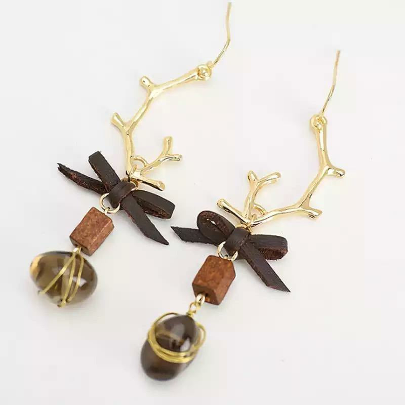 Antique gold plated, gold filled earwire with a beautiful accented leather bow, wooden box that dangles a wired wrapped brown gem (dusty quartz).