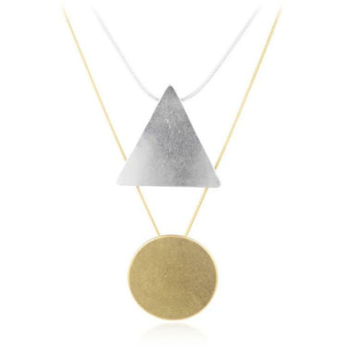 layered gold and silver necklace with geometric triangle circle pendants. 