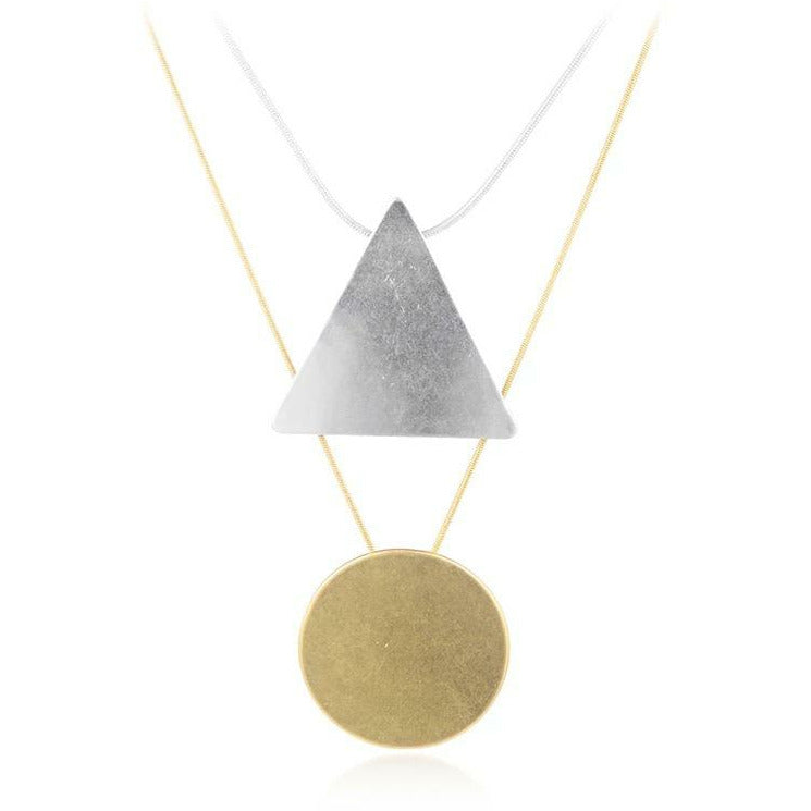 layered gold and silver necklace with geometric triangle circle pendants. 