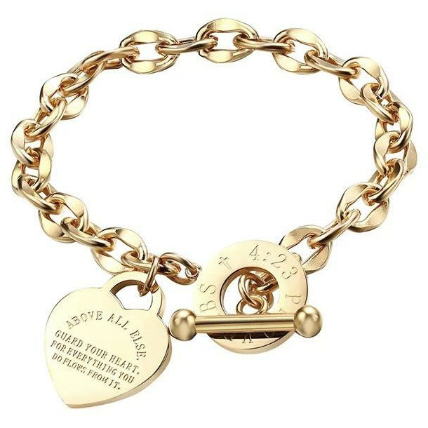 Stainless steel inspirational, heart charm bracelet that’s engraved with the motivational saying, “Above all else, guard your heart, for everything you do flows from it. Proverbs 4:23” Gold